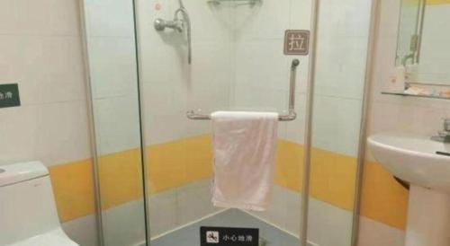 a bathroom with a glass shower with a towel at 7 Days Inn Changchun Zhengyang Street Changchun Park Branch in Changchun