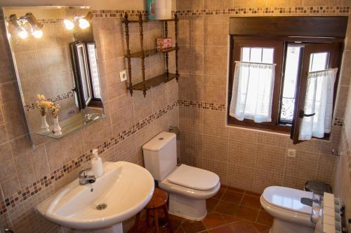 uma casa de banho com um WC branco e um lavatório. em Casa Rural Duquesa De La Conquista de Ávila em Vega de Santa María