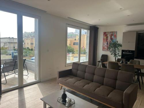 a living room with a couch and a table at New 3 Bedroom Apartment Mellieha w Large Terrace & Panoramic Views in Mellieħa