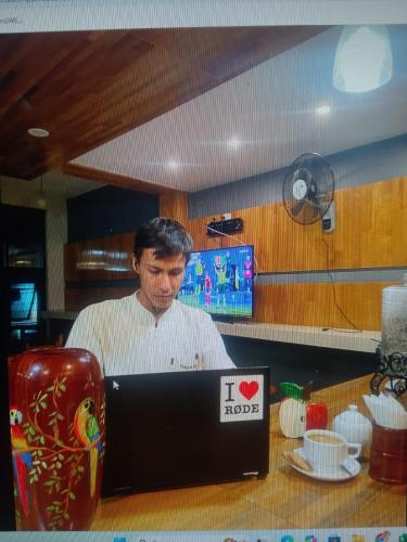 a man standing behind a counter with a laptop computer at Casa Nativa Iquitos in Iquitos