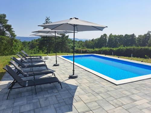 Un grupo de sillas y una sombrilla junto a una piscina. en Villa Sunset, en Banja Luka