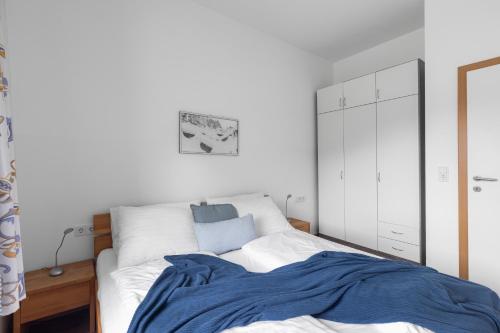 a bedroom with a bed with a blue blanket on it at Alte Schule in Rattendorf
