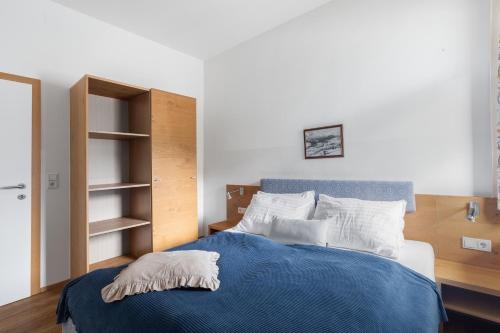 a bedroom with a bed with a blue blanket and white pillows at Alte Schule in Rattendorf