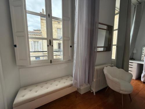 una camera con finestra, panca e sedia di La villa du Consulat - Hôtel Particulier - Ascenseur - piscine - Bordeaux a Bordeaux