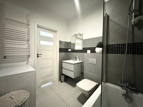 Un baño con lavabo, inodoro y ducha. en Dubois 7 Apartment - Self Check-In 20h - LIFT, en Wroclaw