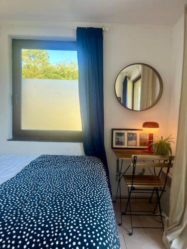 a bedroom with a bed and a window with a mirror at Appartement lumineux au coeur de Han sur Lesse in Han-sur-Lesse