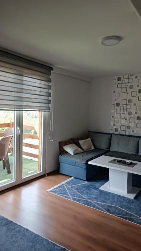 a living room with a couch and a table at Sun-Moon Apartment in Zbilje