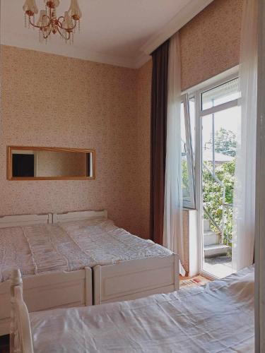 a bedroom with two beds and a large window at tata's house in Kobuleti