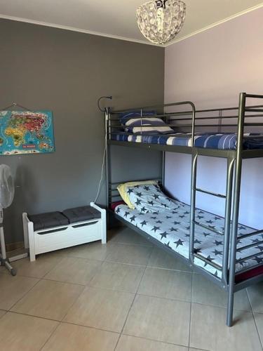 a room with three bunk beds and a chandelier at Maison idéal Familles nombreuses in Graveson