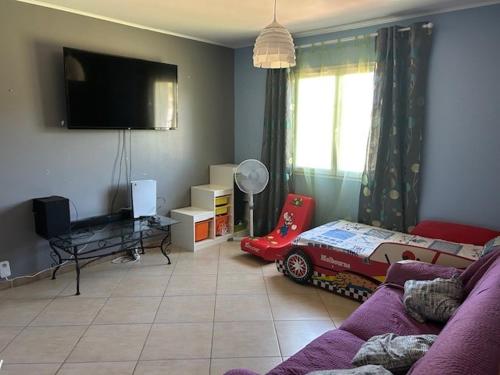 a living room with a couch and a toy car on the wall at Maison idéal Familles nombreuses in Graveson