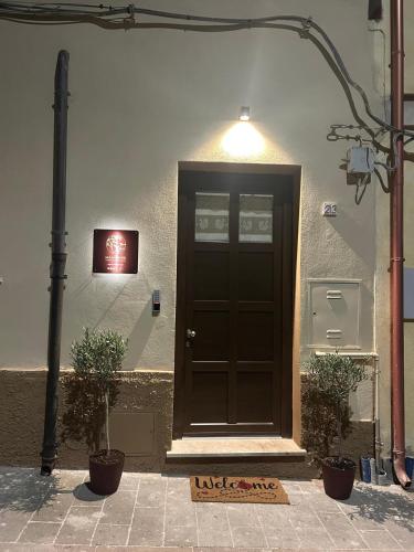 a black door on the side of a building with two plants at Mandrire in Usini