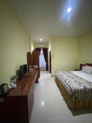 a hotel room with a bed and a desk at Soeltan Luxe Hotel Lampung in Bandar Lampung