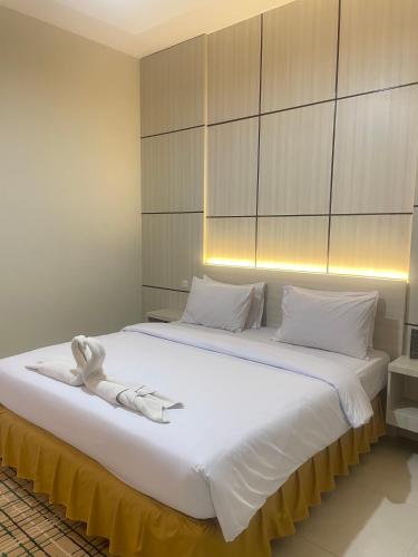 a large white bed with a towel on it at Soeltan Luxe Hotel Lampung in Bandar Lampung