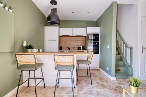 a kitchen with a counter and stools at Maison cosy rénovée, tout à pied, plage et gare in Trouville-sur-Mer