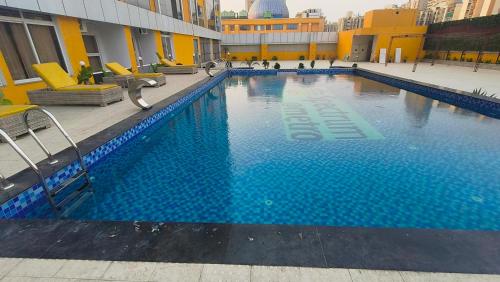 a large swimming pool with blue water in a building at Swimming Pool with Full Equipped Studio Apartment in Noida