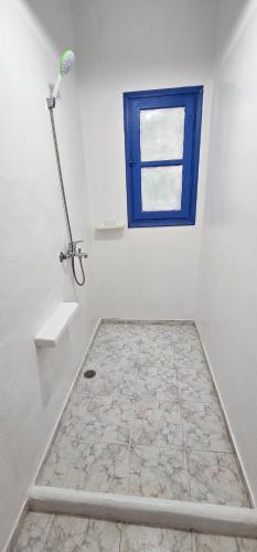 a bathroom with a shower and a blue window at Hotel Pleasure Black Beach Perissa Santorini in Perissa