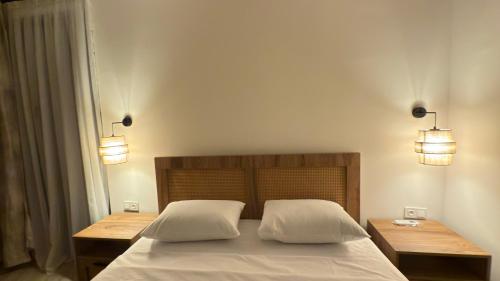 a bedroom with a bed with two tables and two lights at Kvariati House in Kvariati