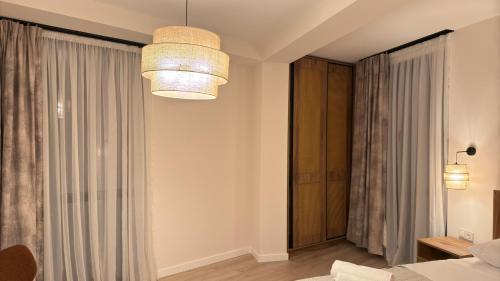 a room with a bed and a chandelier at Kvariati House in Kvariati