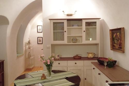 a kitchen with a table with a vase of flowers at Apartmán Veles Banská Štiavnica in Banská Štiavnica