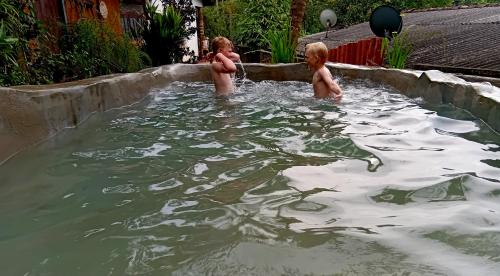 dos niños jugando en un charco de agua en Ancient Grand Villa, en Pinnawala