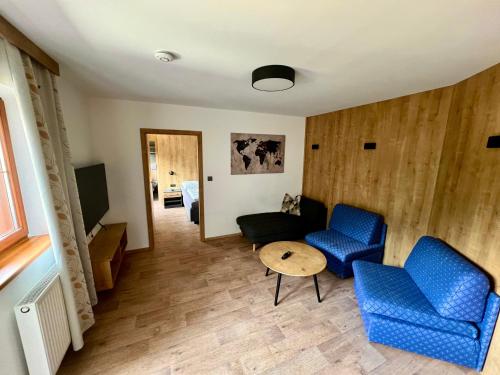 a living room with blue chairs and a table at Pension Marina in Tux