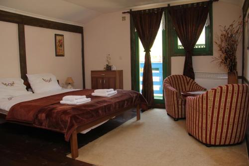 a bedroom with a bed and a chair and a window at Eco village Raj u raju in Konjic