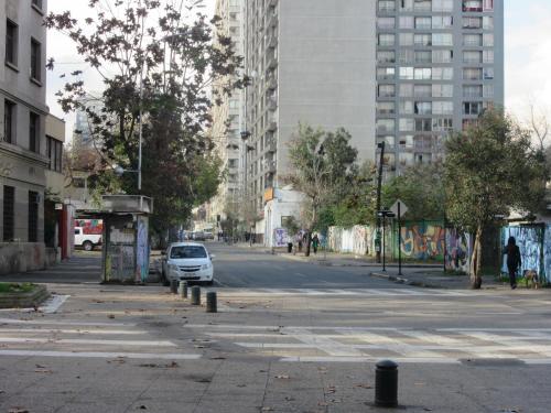 a white car parked on a city street with buildings at Departamento Paseo Bulnes Metro La Moneda in Santiago