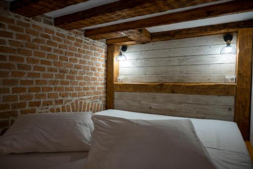 a bed in a room with a brick wall at Boutique 11 Postavarului by Kronstay in Braşov