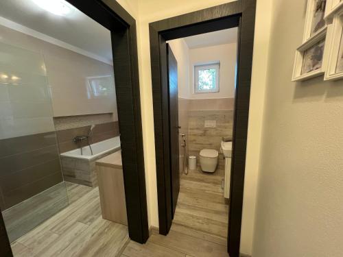 a bathroom with a tub and a toilet and a sink at Apartmán LUNA Trenčín in Trenčín