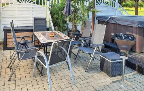 a patio with a table and chairs and an umbrella at Ferienwohnung Nepperminusedom in Neppermin