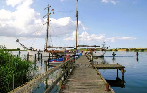 a dock with two boats and a sail boat on the water at Ferienwohnung Nepperminusedom in Neppermin