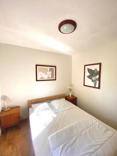 a bedroom with a white bed and two pictures on the wall at Village de vacances oignies in Oignies-en-Thierache