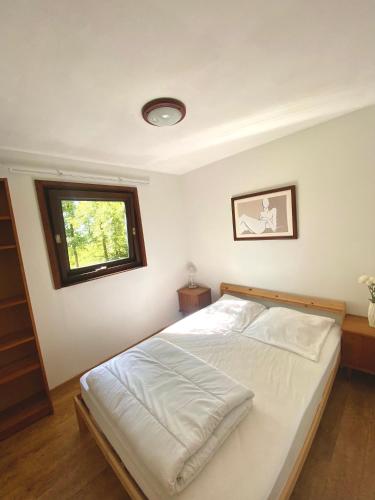 a bedroom with a white bed with a window at Village de vacances oignies in Oignies-en-Thierache