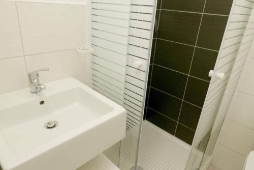 a white bathroom with a sink and a shower at Appartamenti Renzo&Rita3 Teresina in SantʼAntìoco