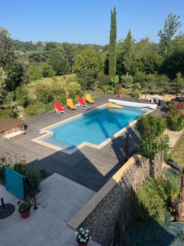 une piscine avec des chaises longues et une piscine dans l'établissement Petit Paradis, à Sarlat-la-Canéda