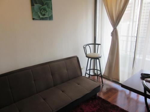 a living room with a couch and a table and a stool at Departamento Paseo Bulnes Metro La Moneda in Santiago
