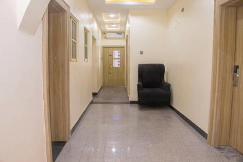 an empty hallway with a chair and a door at Correct Residence and Resort in Abuja