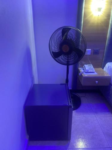 a blue room with a fan on top of a table at Correct Residence and Resort in Abuja