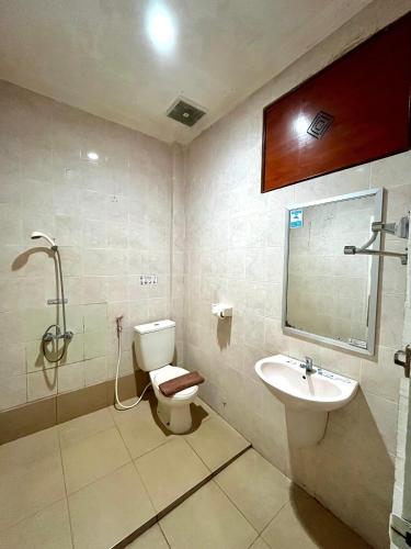 a bathroom with a toilet and a sink at Soeltan Luxe Hotel Lampung in Bandar Lampung
