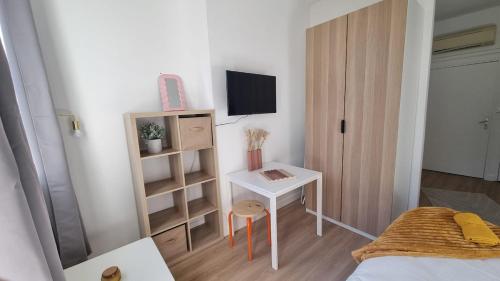 a small room with a bed and a desk and a television at Studio Gauche Calme Proche Gare Climatisation in Bordeaux