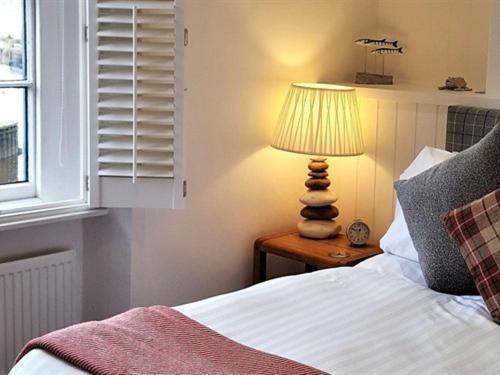 a bedroom with a bed and a lamp on a table at The Steam Packet Inn in Totnes