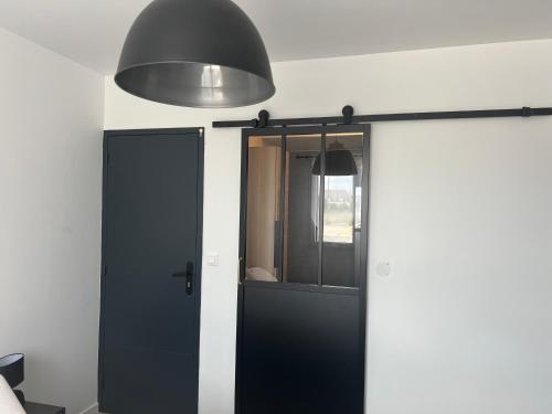 a black door in a room with a lamp at Ma Bro - ERDIVINES in Erdeven