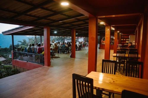 a restaurant with a table and chairs and people on a balcony at ที่พัก in Ban Ko Doi Tung
