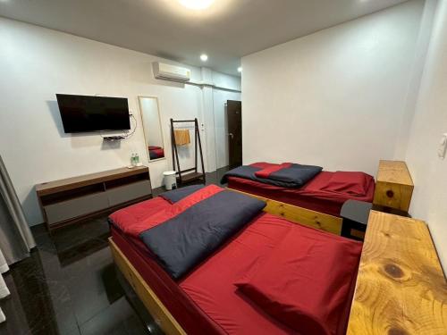 a room with two beds and a tv on the wall at ที่พัก in Ban Ko Doi Tung