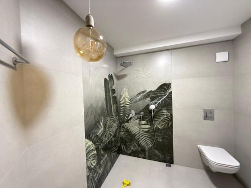 a bathroom with a toilet and a painting on the wall at Kvariati House in Kvariati