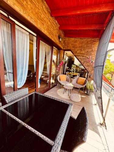 a large screened in porch with a table and chairs at Spa Residence Családi Wellness Apartman in Veszprémfajsz
