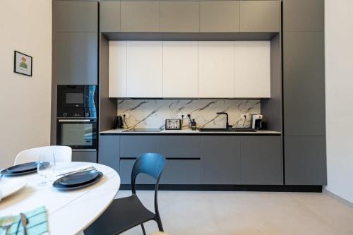 cocina con mesa blanca y silla azul en Casa Gemma Rome, en Roma