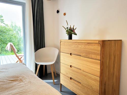 a bedroom with a dresser and a window at Westertilli Middelhuus - modernes, luxuriöses Wohngefühl in Pellworm