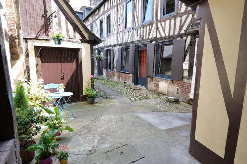 an alley with a table and a building at Nid normand en bâtisse 1620 - Calme & hyper centre in Pont-Audemer