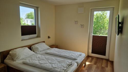 a bedroom with two beds and two windows at Ferienwohnung Seeblick in Altefähr